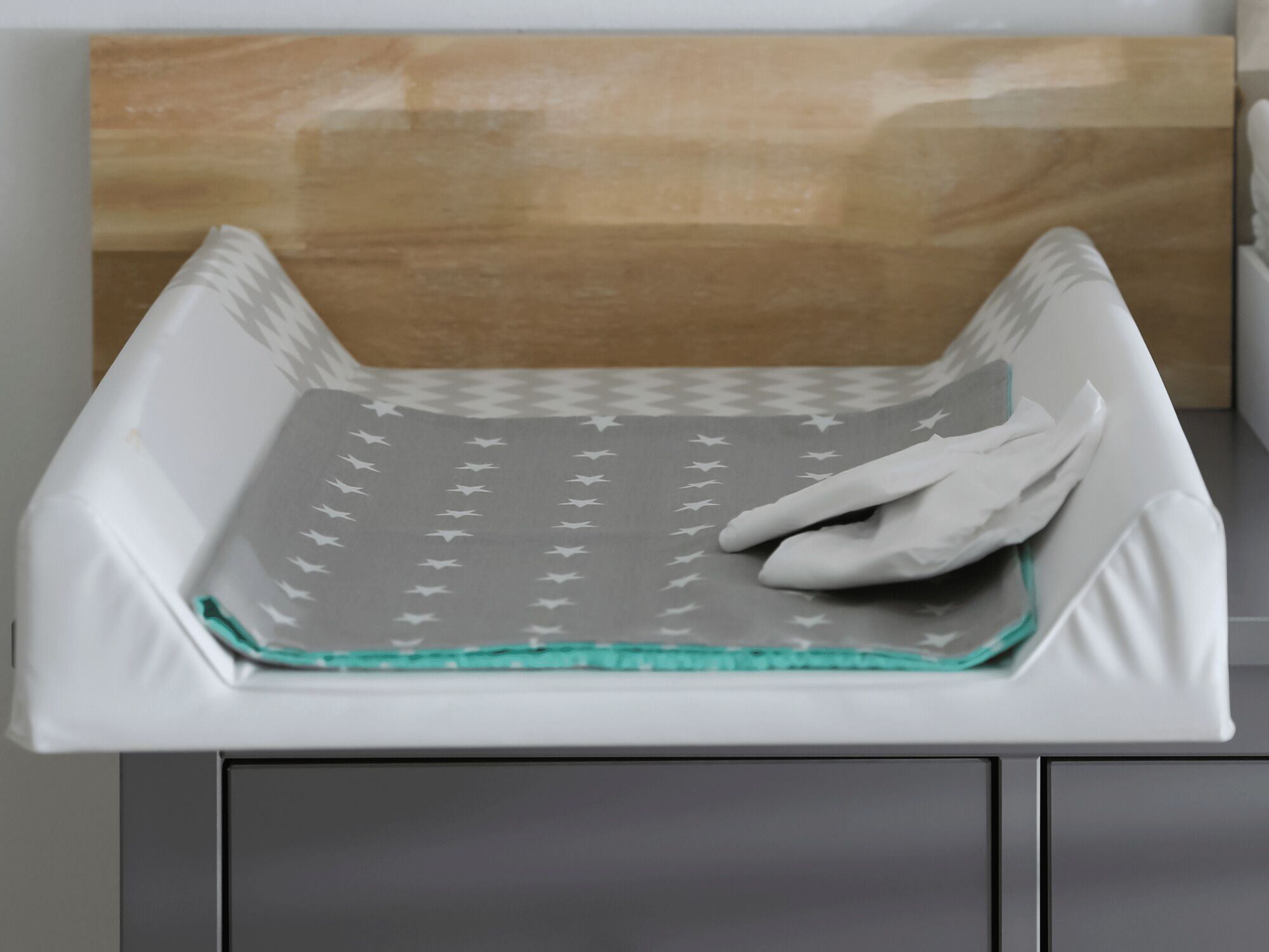 Una cucina con piano di lavoro bianco, rivestimento a parete in legno e elettrodomestico bianco con decorazioni.