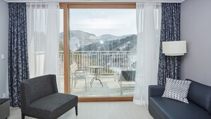 A modern room with a balcony, a sofa, a chair, and a table. - I Want Resort (Pyeongchang)