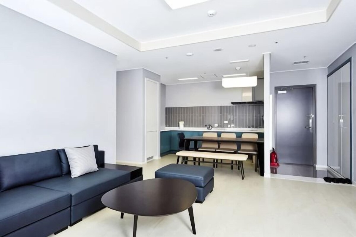 Una sala moderna con un sofá, una mesa de centro y un comedor con sillas y una mesa.