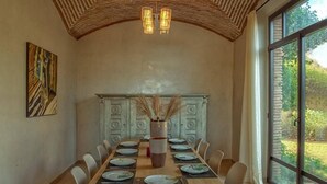 A dining area with a long wooden table set for a meal, surrounded by chairs. - Villa De Luxe Samanah (Marrakech)