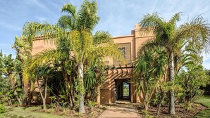 A building with a modern architectural style, surrounded by lush tropical vegetation. - Villa De Luxe Samanah (Marrakech)