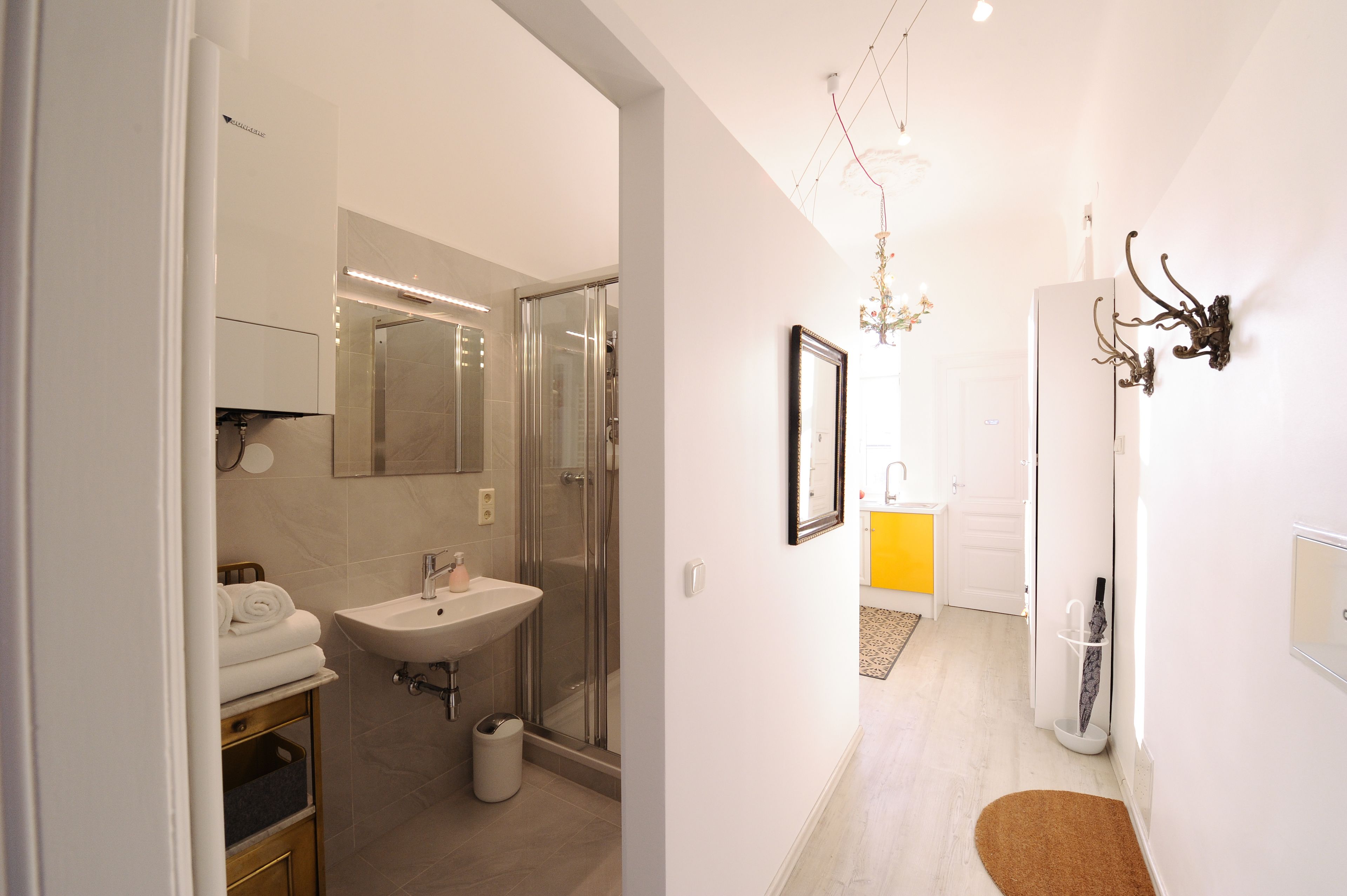 A modern bathroom with a glass shower, a sink, and a mirror.