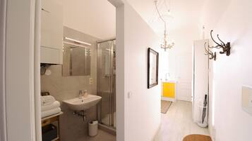 A modern bathroom with a glass shower, a sink, and a mirror.