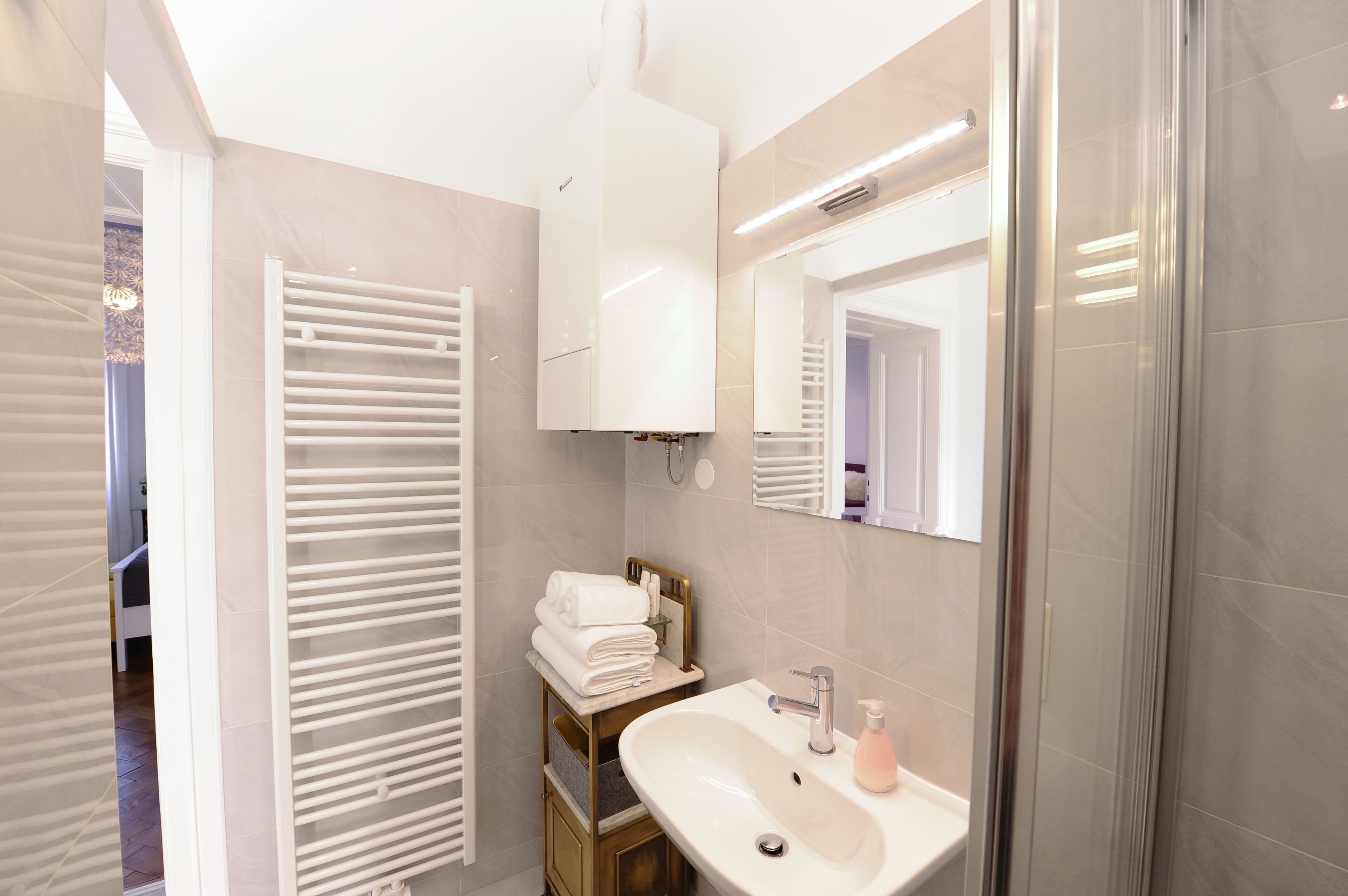 Un bagno moderno con lavandino, specchio e portasciuga in bianco.