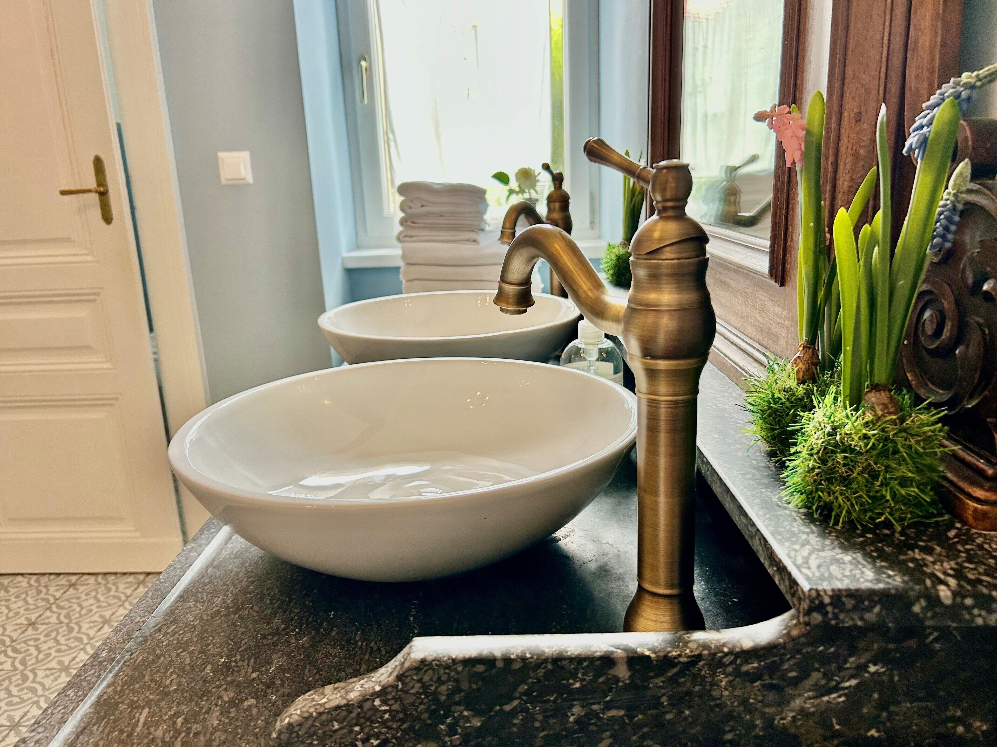 Ein Badezimmer mit zwei Waschbecken, einem Wasserhahn und einem Spiegel.