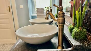 Ein Badezimmer mit zwei Waschbecken, einem Wasserhahn und einem Spiegel.