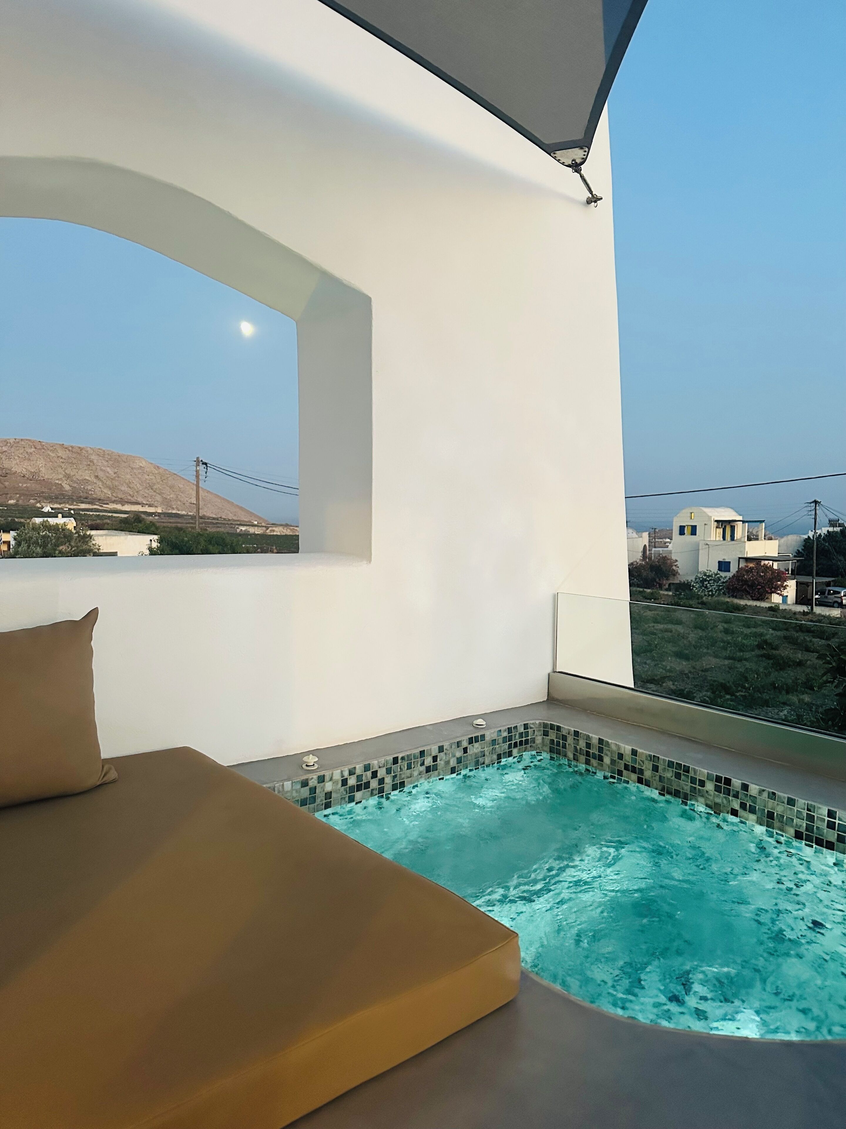 Una habitación moderna con un ventanal grande, una piscina pequeña y un sofá.