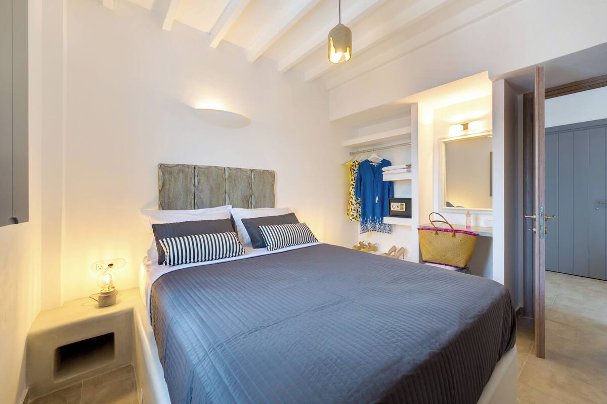 Una camera da letto con un letto grande, un comodino con una lampada, uno specchio e un armadio.