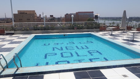 Una piscina al aire libre, sombrillas