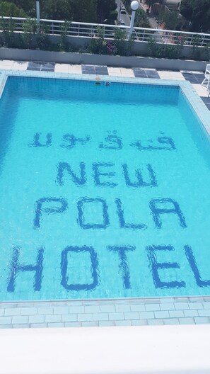 Una piscina al aire libre, sombrillas