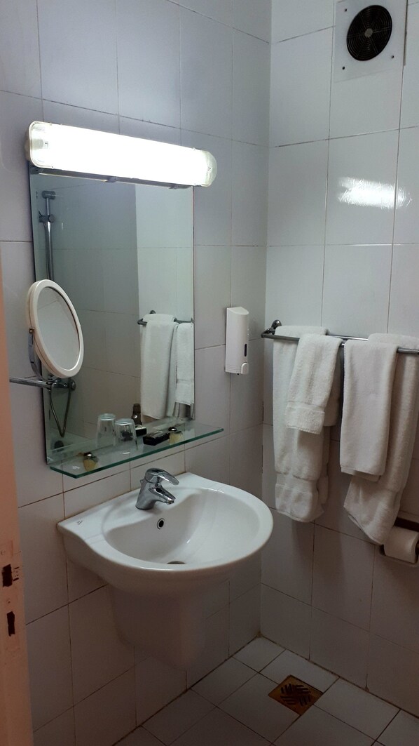 A bathroom with a white sink, a mirror, and two white towels hanging on a rack. - New Pola hotel (Luxor)