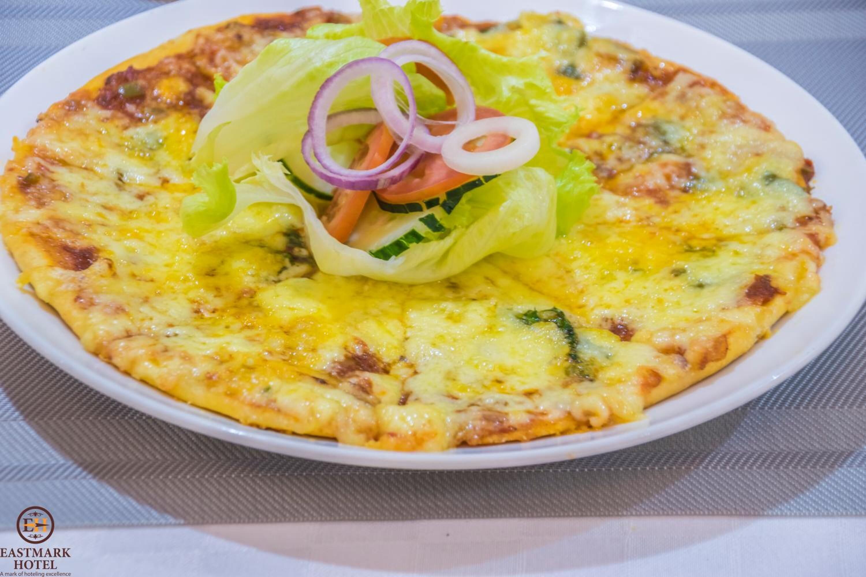 A pizza with toppings and a side salad on a plate.