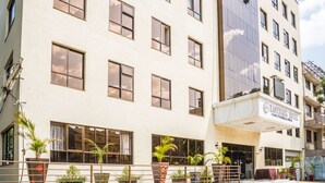 A multi-story hotel with a modern facade, large windows, and a prominent entrance with a sign. - Eastmark Hotel (Nakuru)