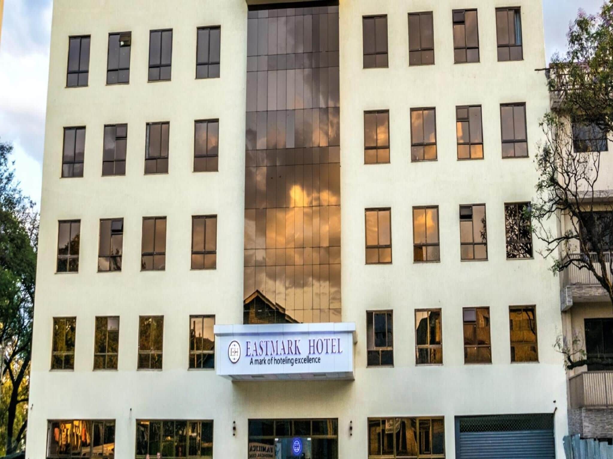Un hotel de varios pisos con un letrero que dice "EASTMARK HOTEL" y un logotipo.