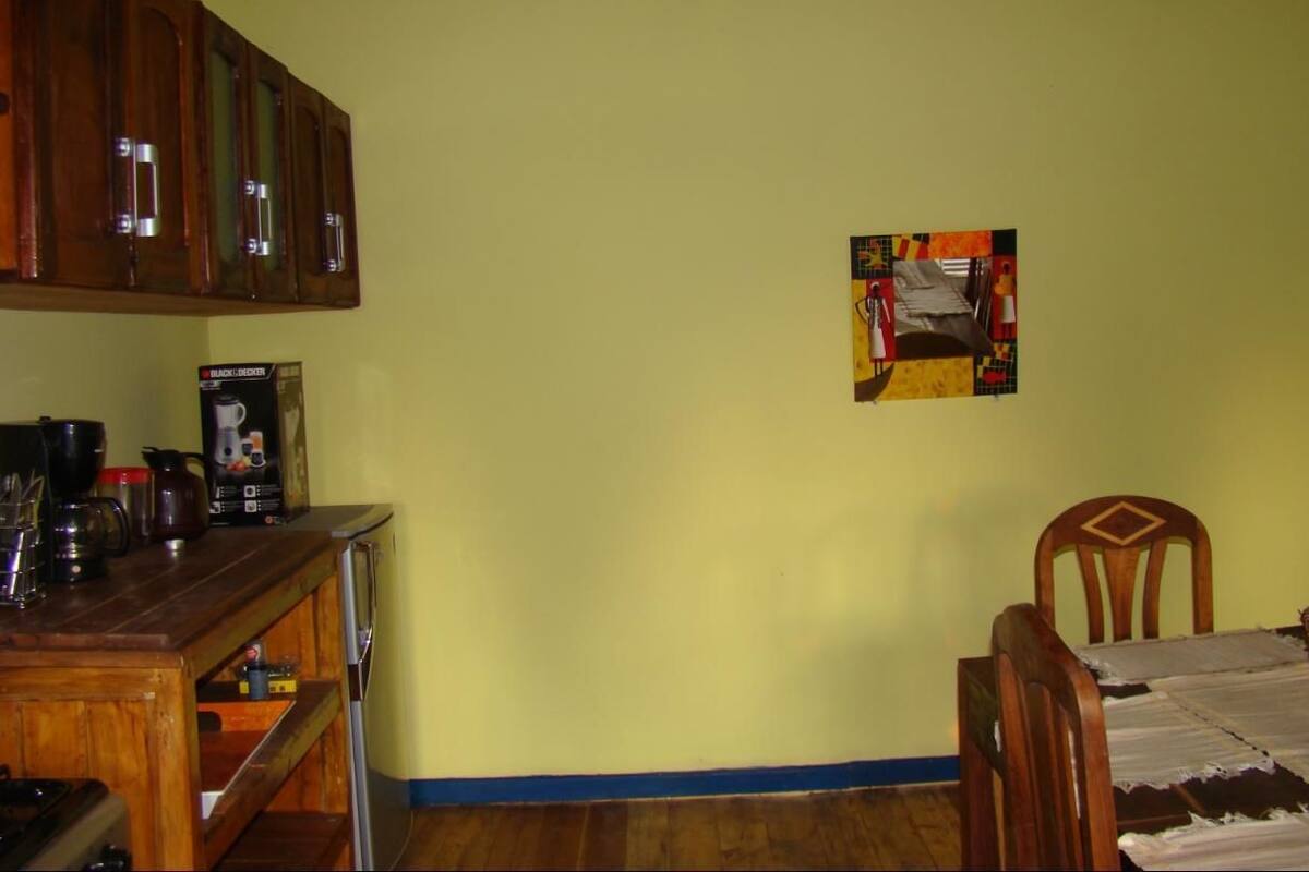 Una habitación con una mesa de madera, una cama y un cuadro en la pared.