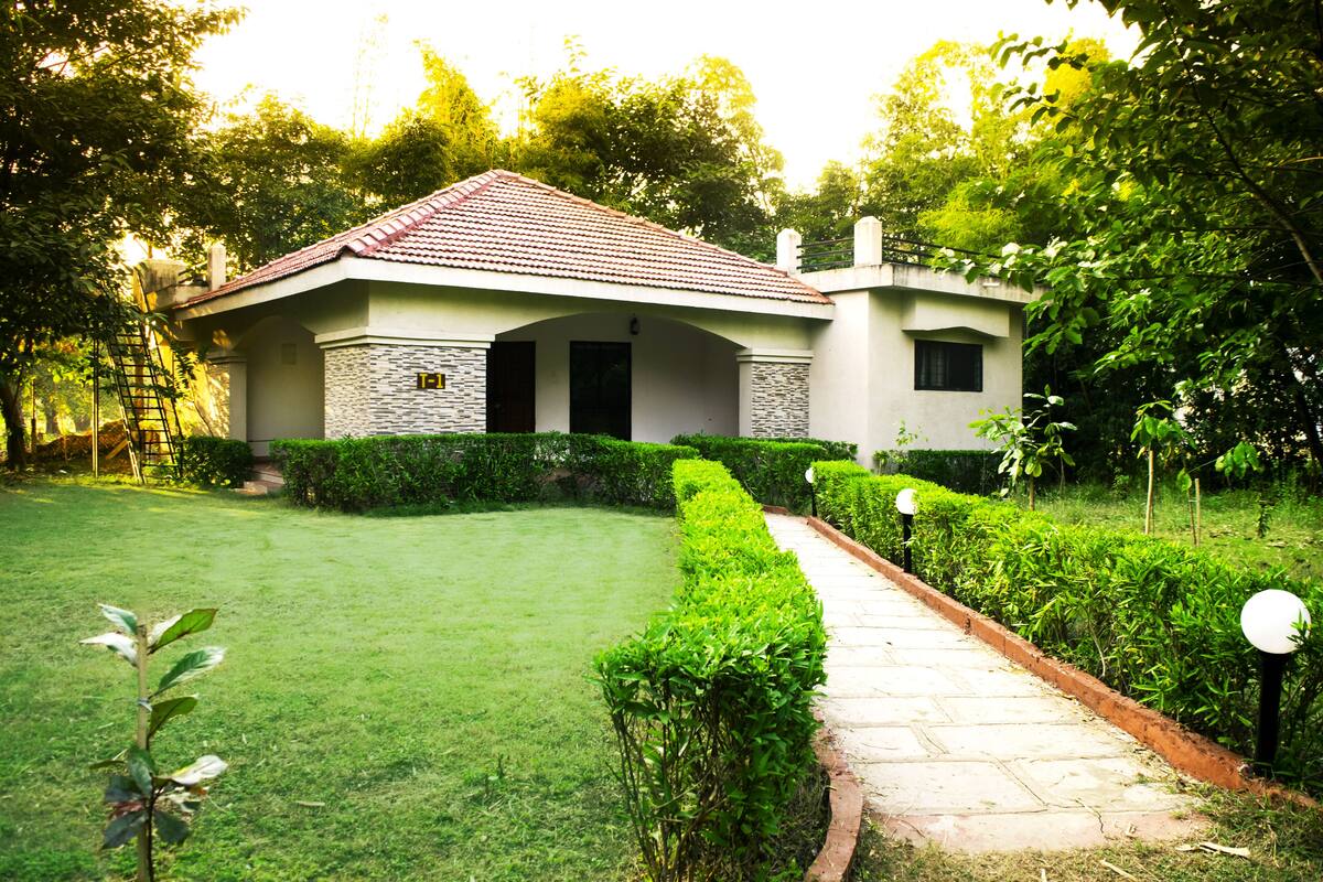 A house with a tiled roof, stone exterior, and a well-maintained lawn.