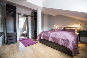A bedroom with a bed, a walk-in closet, a purple rug, and a skylight. - Hotel und Restaurant Fackelgarten (Plau am See)