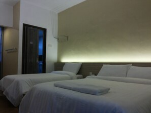 A hotel room with two beds, a wooden headboard, and a door leading to a balcony. - Suria Cameron Hotel (Tanah Rata)