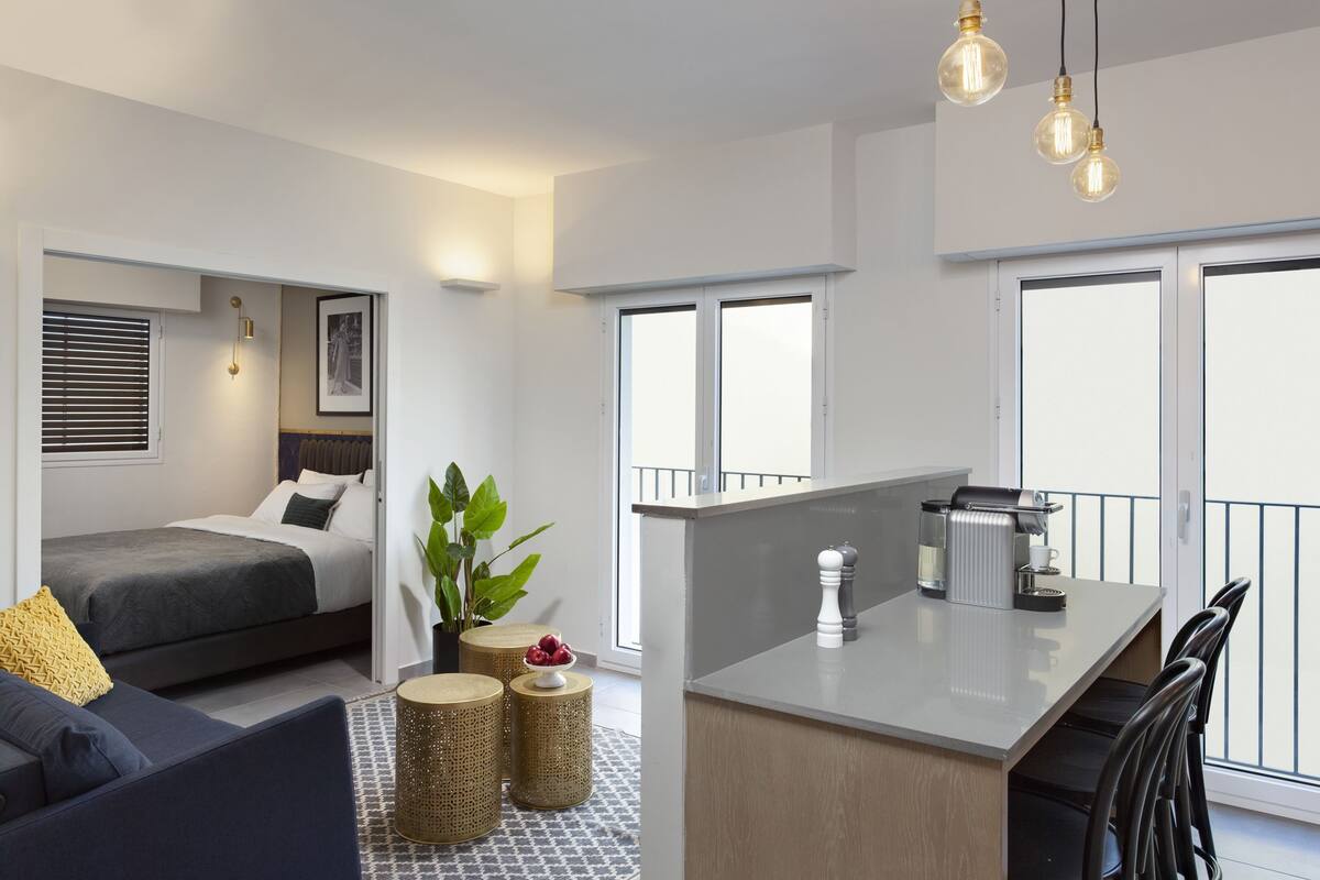 Eine moderne, kompakte Wohnung mit einer Küchenzeile, einem Essbereich und einem Schlafbereich.