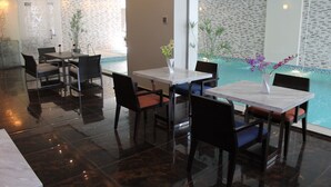A modern indoor pool area with seating arrangements and a view of the pool.