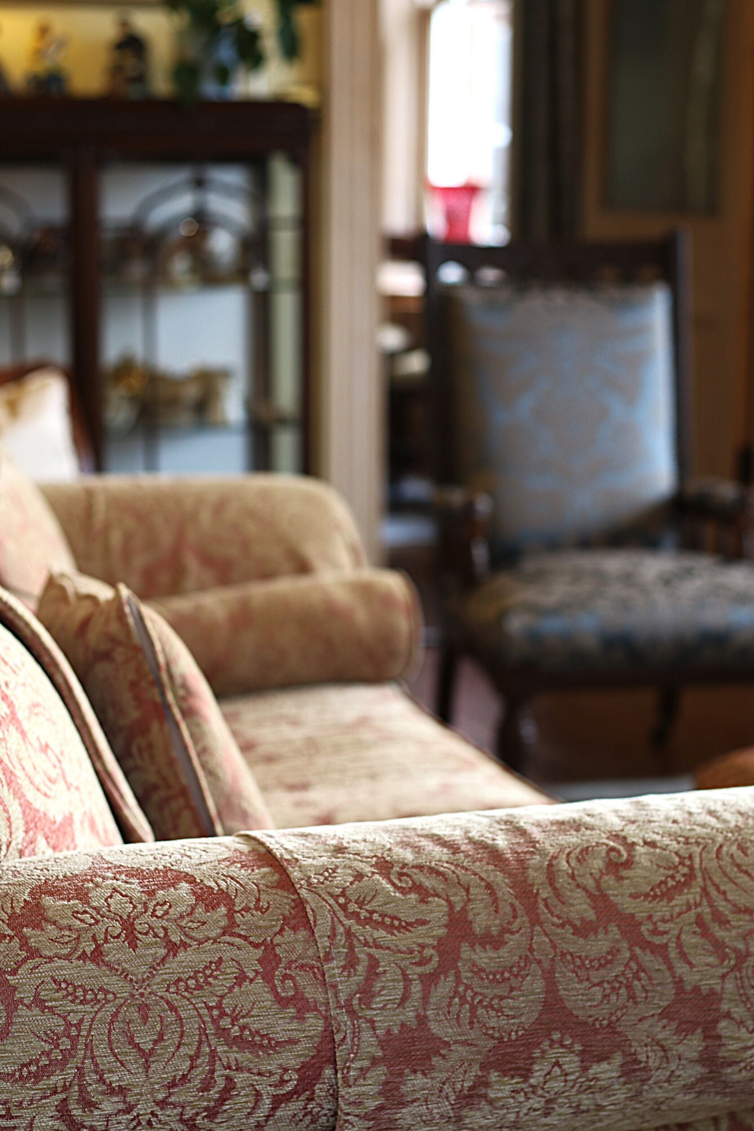 A living room with a patterned sofa and a blue armchair.