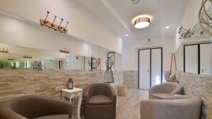A modern lobby with a stone wall, a large mirror, and two sofas.