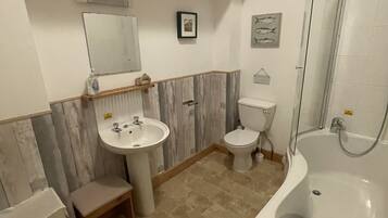 A bathroom with a sink, toilet, and bathtub.