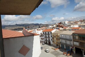 A residential area with buildings, a street, and mountains in the background.