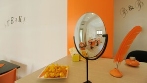 Una habitación con un espejo, una bandeja de aperitivos y una pluma decorativa.