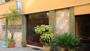 Un edificio con fachada de piedra, ventanas amplias y plantas en macetas.