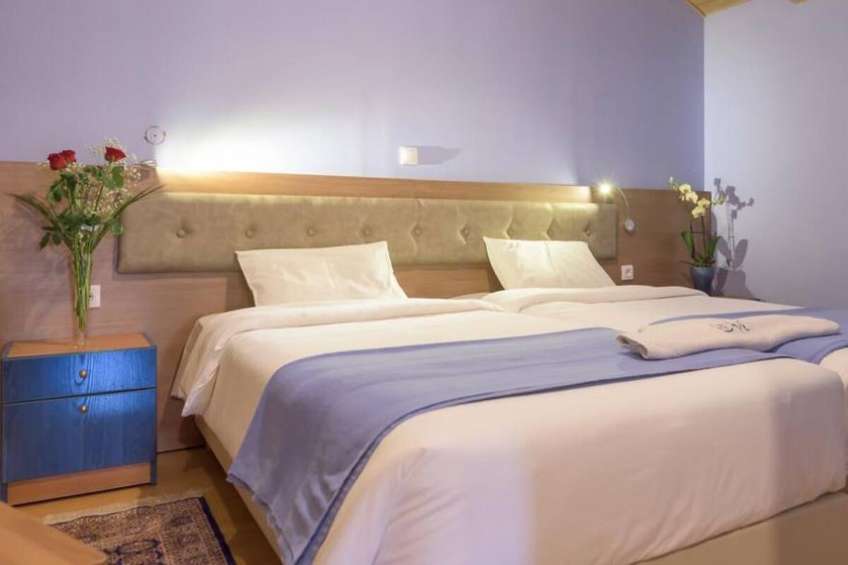 A double bed with a tufted headboard, two bedside tables, and a nightstand.