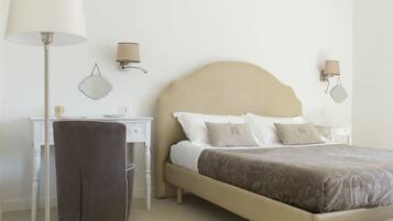 A neatly arranged bedroom with a bed, bedside tables, a desk, and a chair.