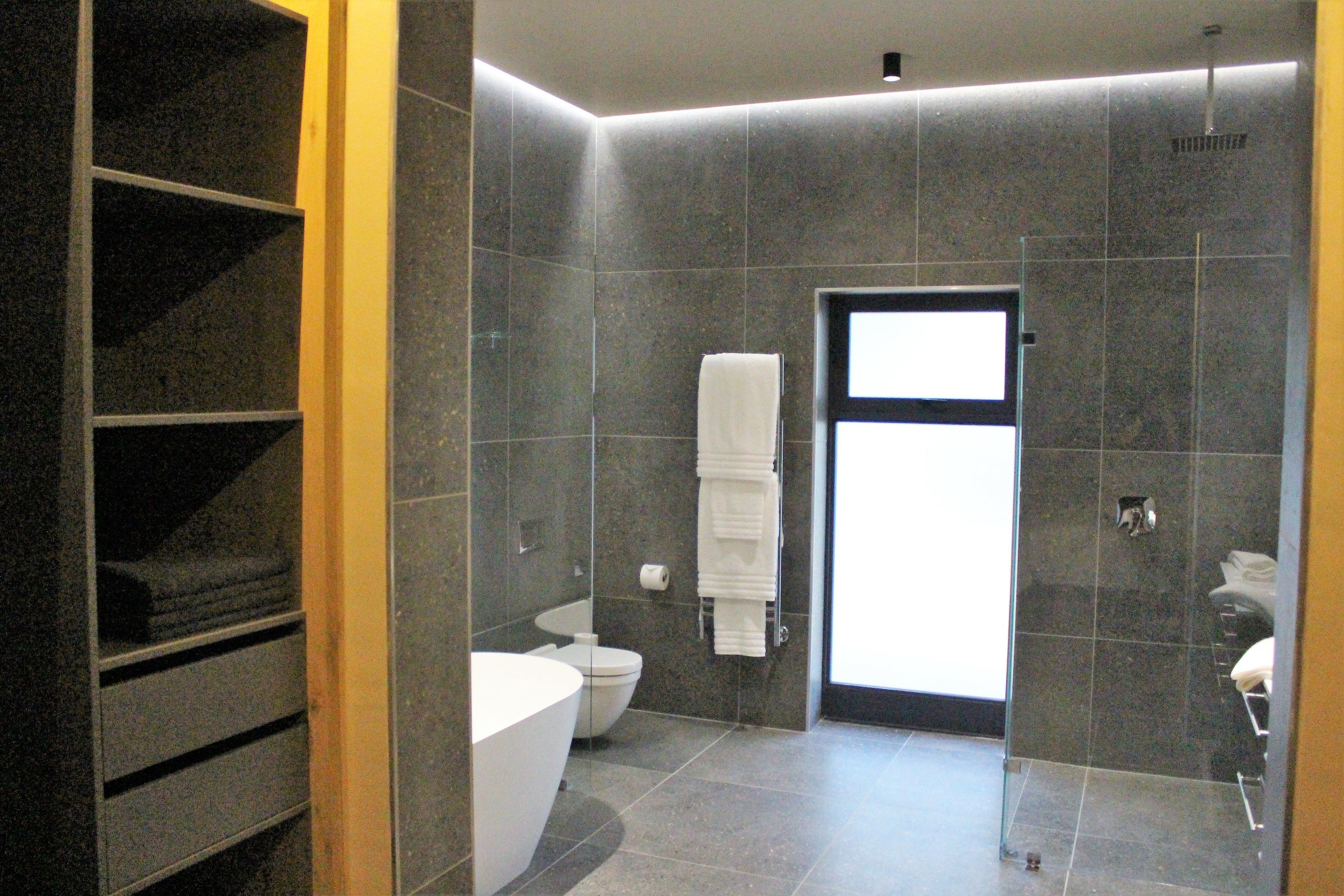 Un baño moderno con bañera, inodoro y zona de ducha.