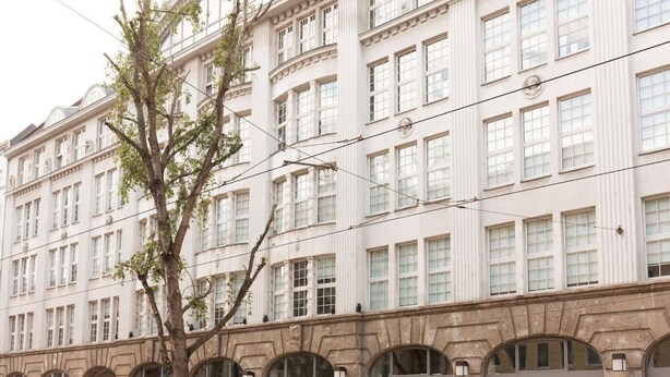 Ein mehrgeschossiges Gebäude im klassischen Stil, mit einer symmetrischen Fassade, gleichmäßig verteilten Fenstern und einem zentralen Eingang.