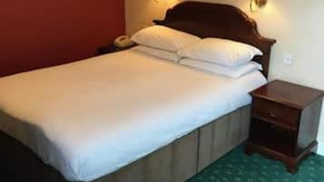 Una habitación de hotel con cama, mesitas de noche y lámparas de pared.
