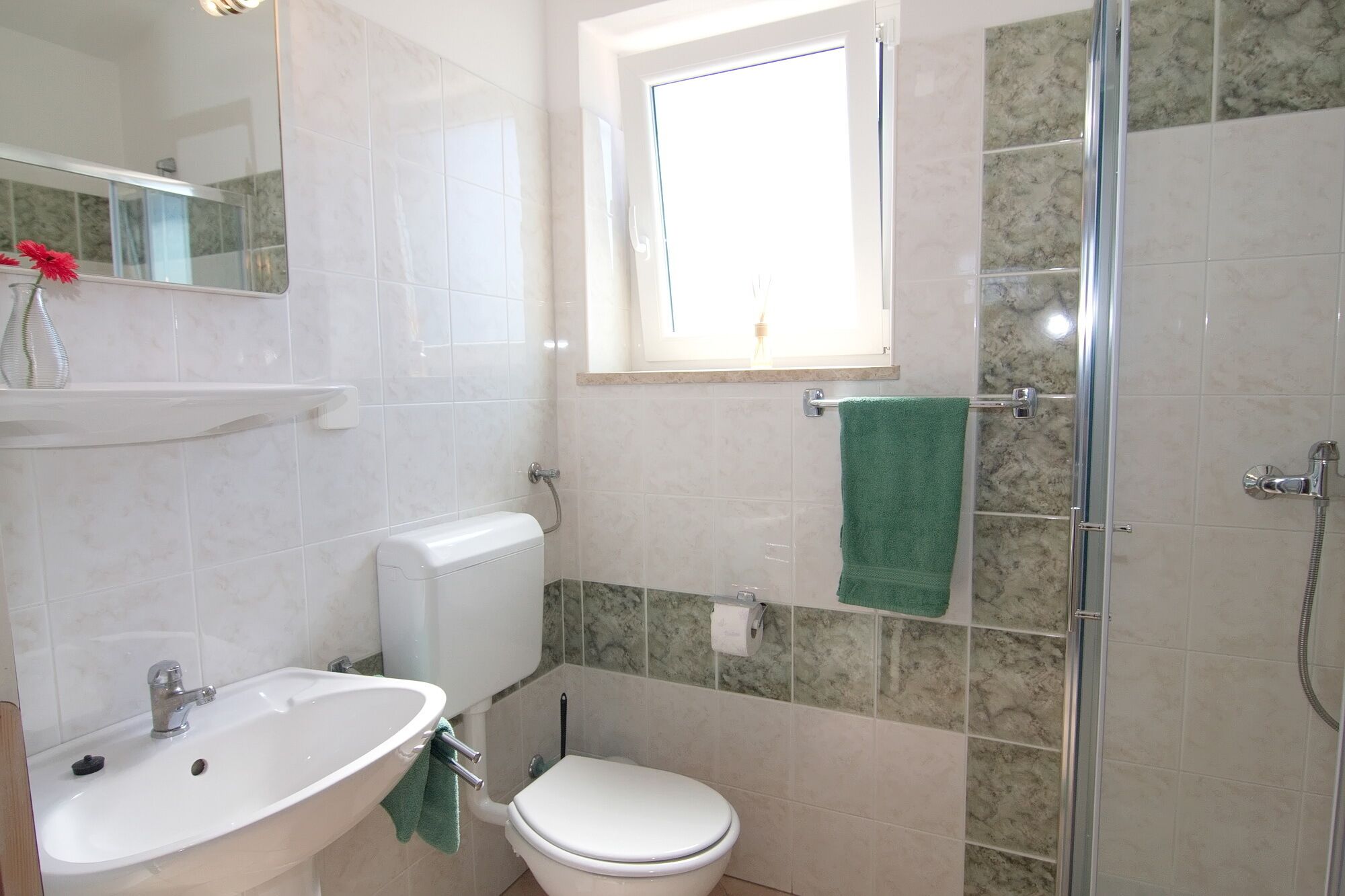 A bathroom with a sink, toilet, and shower.