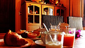 A breakfast setting with croissants, orange juice, and a pitcher of milk on a wooden table. - Is Scabas (Solarussa)