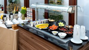 Un buffet proposant une variété de plats, une vitrine réfrigérée et un assortiment de boissons.