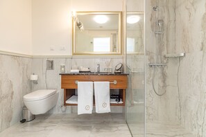 Een regendouche, designer toiletartikelen, een haardroger, badjassen