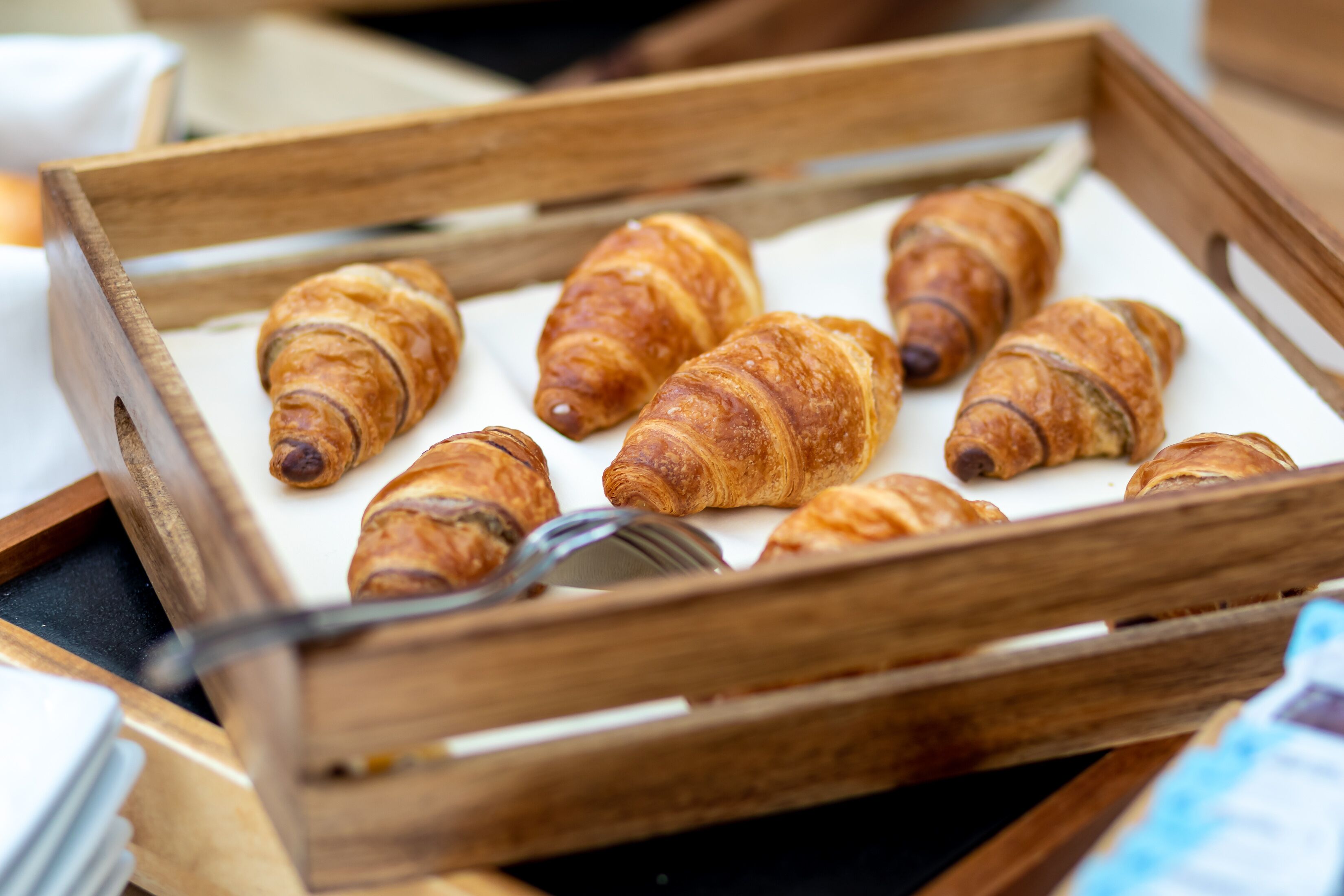 A wooden tray with croissants.