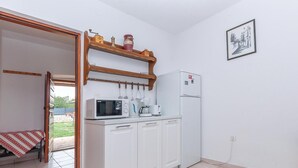 A compact kitchen with white cabinets, a microwave, a coffee maker, and a refrigerator. - Beautiful home in Oklaj (Oklaj)