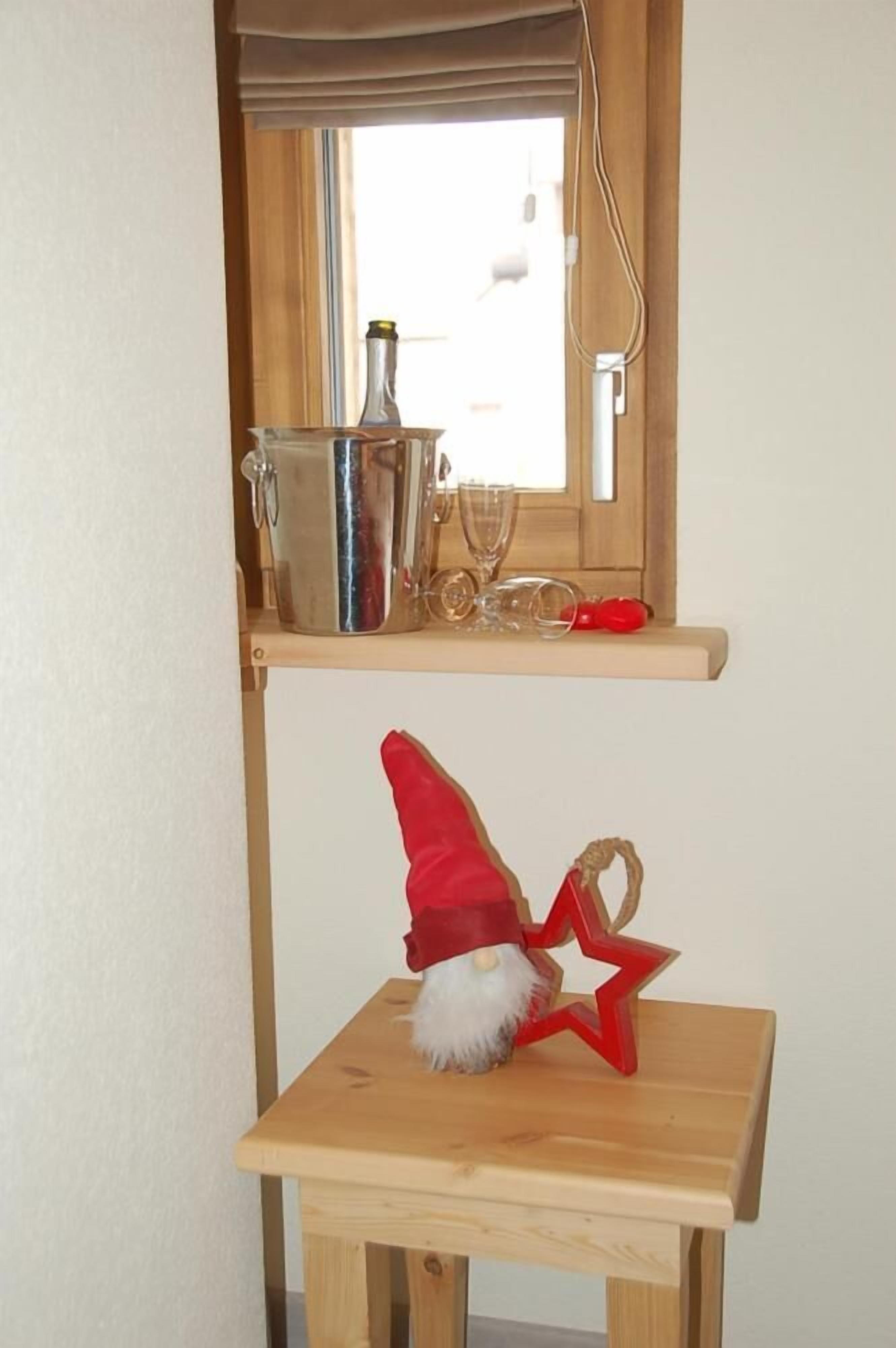 A small wooden table with a red star decoration and a Santa hat.