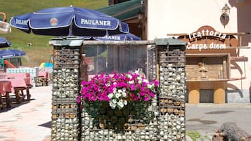 Una estructura de piedra con flores y un letrero que dice "Trattoria Carpe diem".