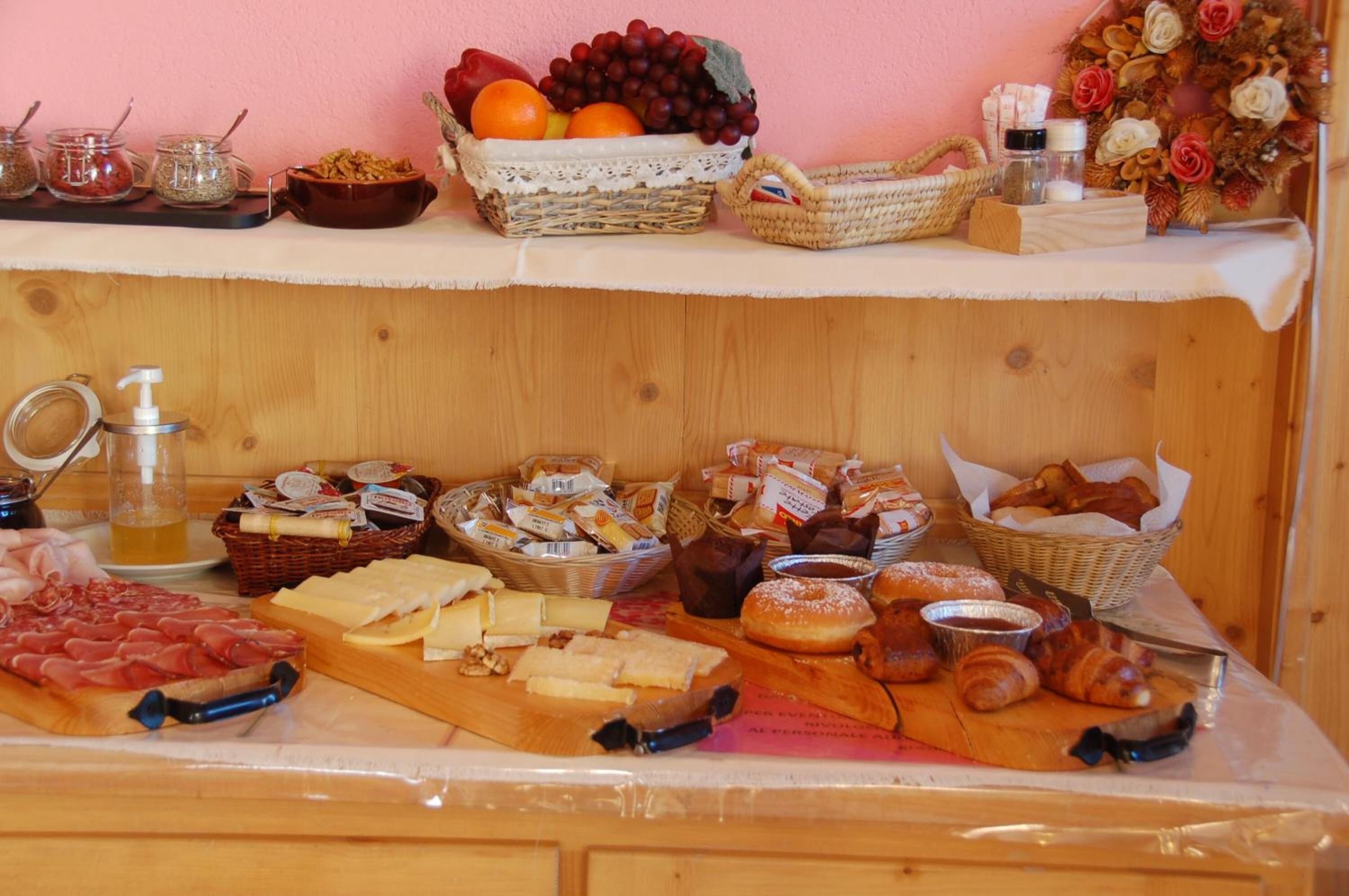 Un bufé con diversos alimentos, incluyendo carnes, quesos, pasteles y frutas.