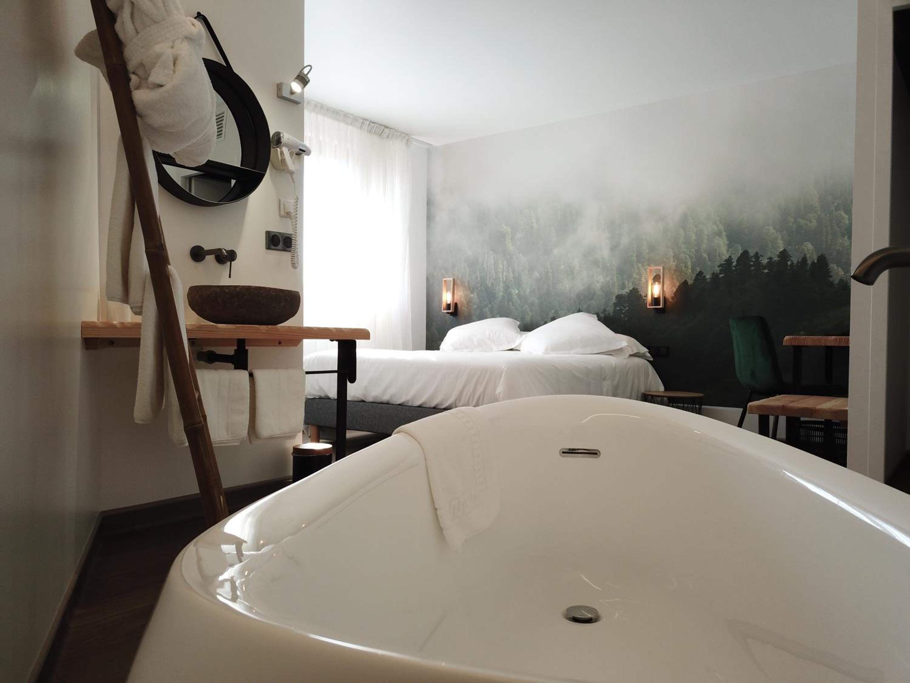 A modern bathroom with a freestanding bathtub, a wooden basin, and a towel rack.
