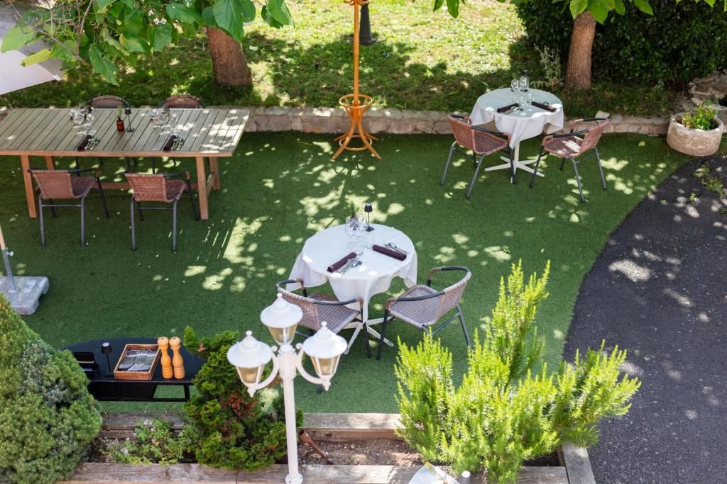 An outdoor patio with two round tables, chairs, and a small table with decorative items.