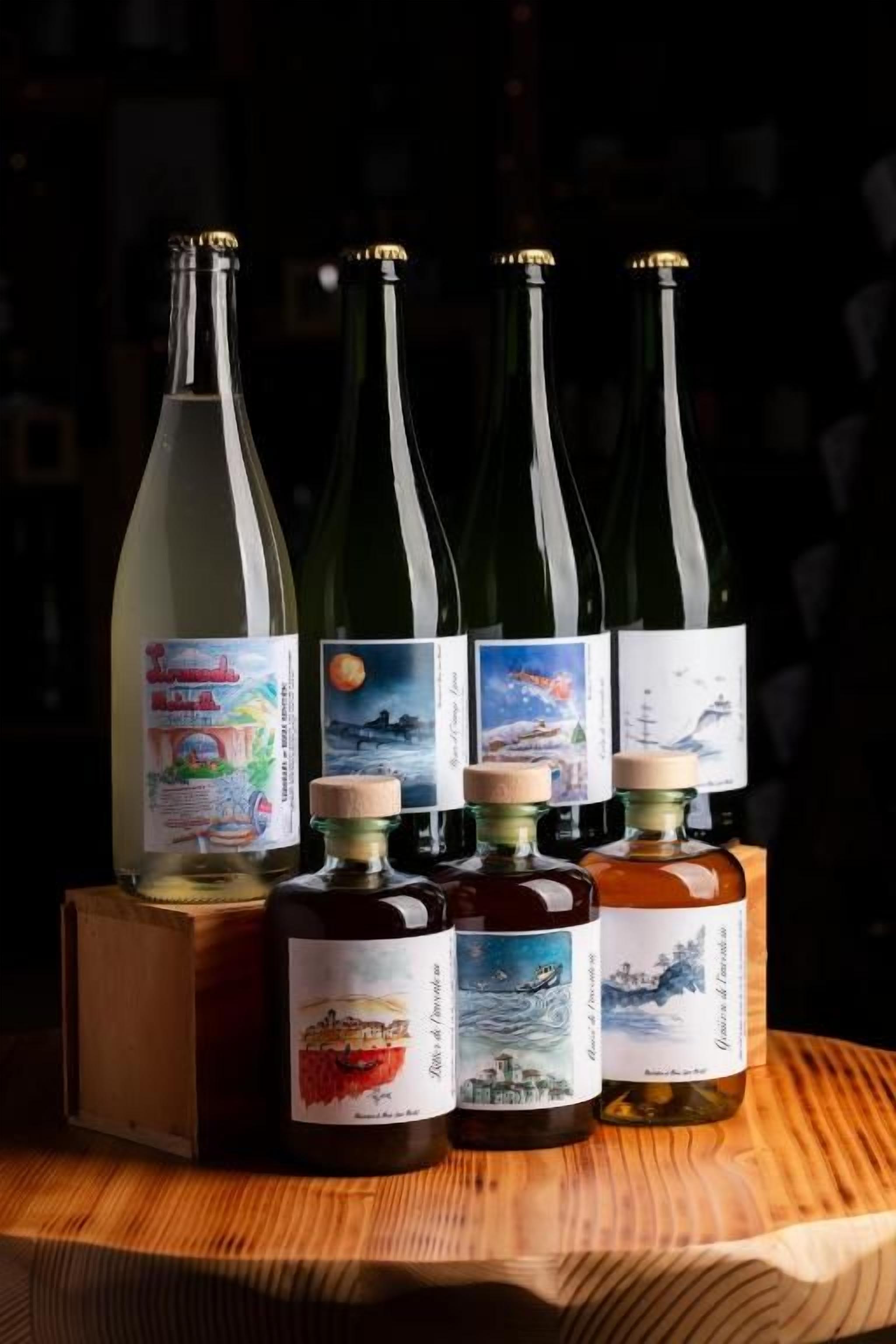 Cuatro botellas de vino sobre una superficie de madera.
