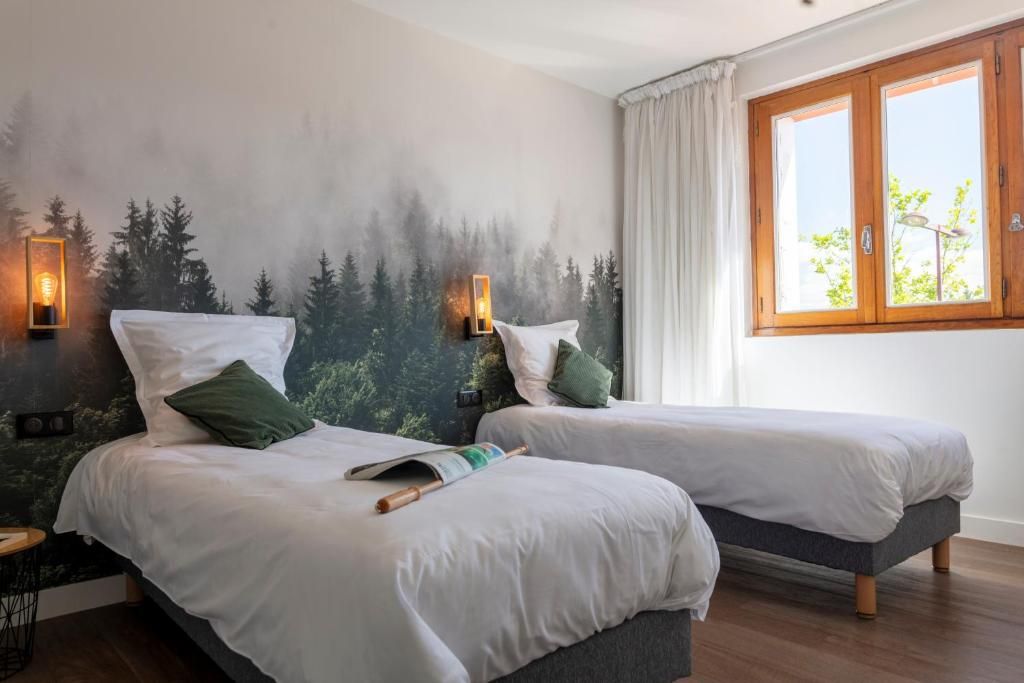 Una habitación con dos camas, una ventana con cortinas y un mural de un bosque en la pared.