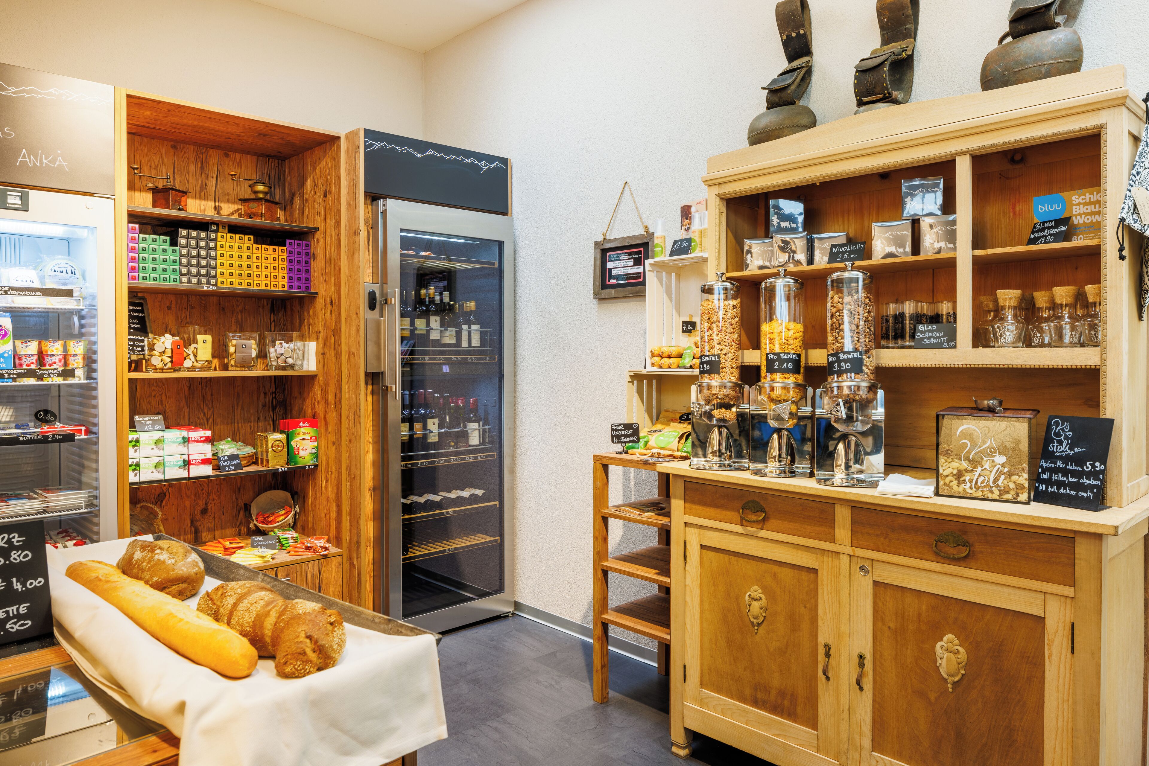 Een bakkerij met een divers assortiment gebak en een vitrine met potten volnoten en andere producten.