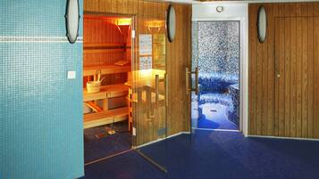 Relax in a serene sauna with a wooden bench area and blue tiled floor.